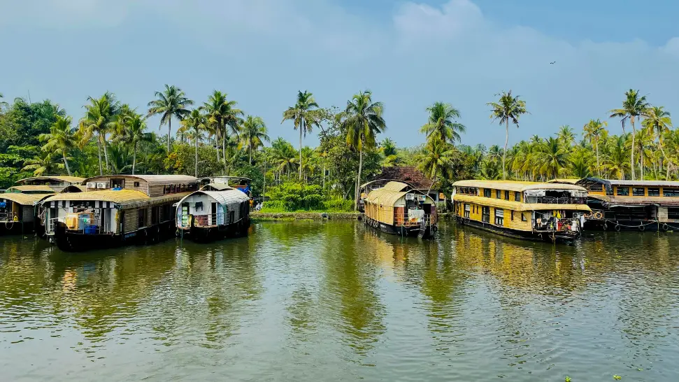 Houseboat cruising through Alleppey backwaters during monsoon
