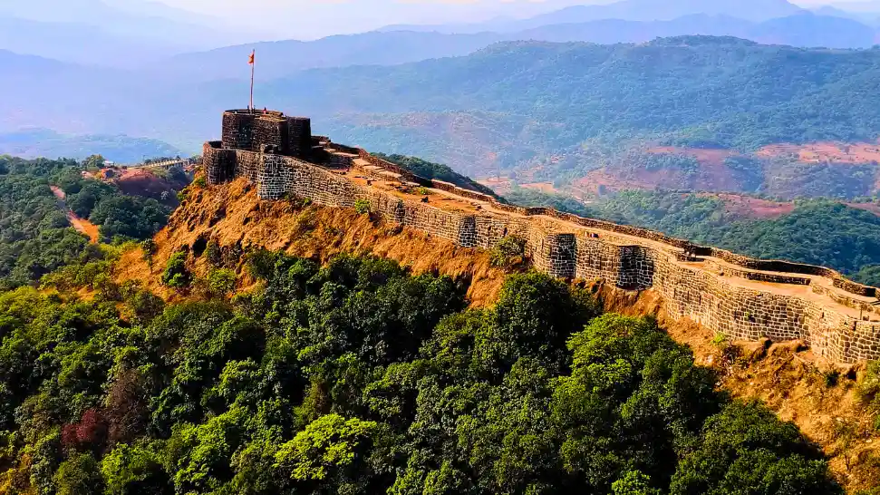 Historic Pratapgarh Fort surrounded by hills and greenery