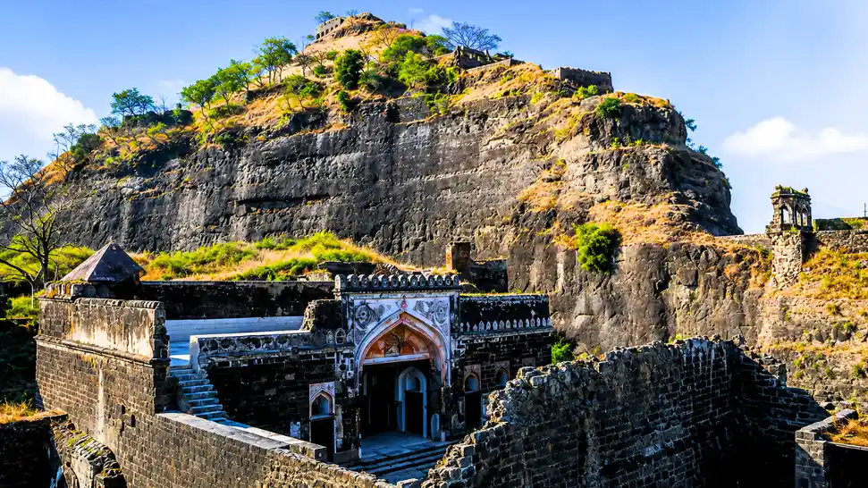 Ancient ruins of Droog Fort surrounded by dense forests and scenic Nilgiri Hill views.