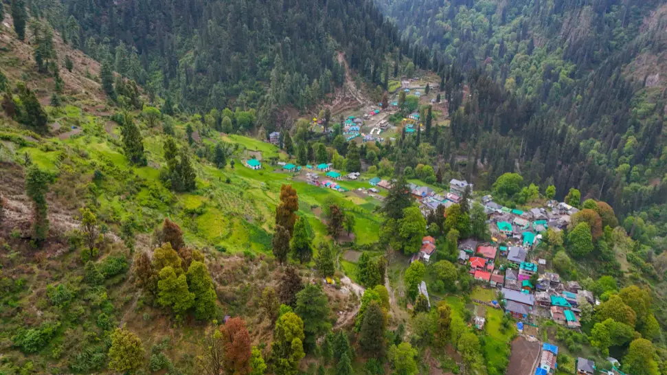 Traditional wooden homes and mountain scenery in Grahan Village