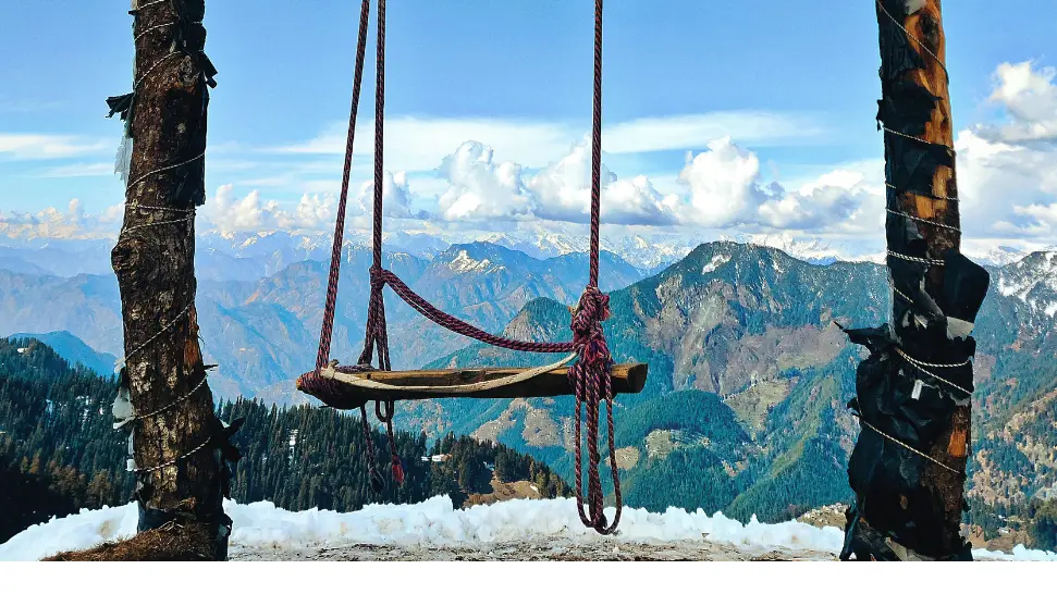 Snow covered forests and wooden houses in Tirthan Valley